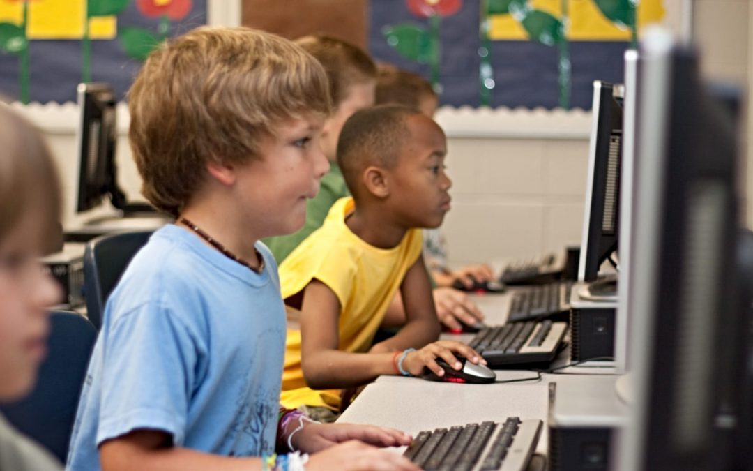 Young children working on computers at school