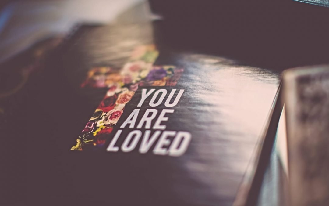 A Bible with the words you are loved on the cover