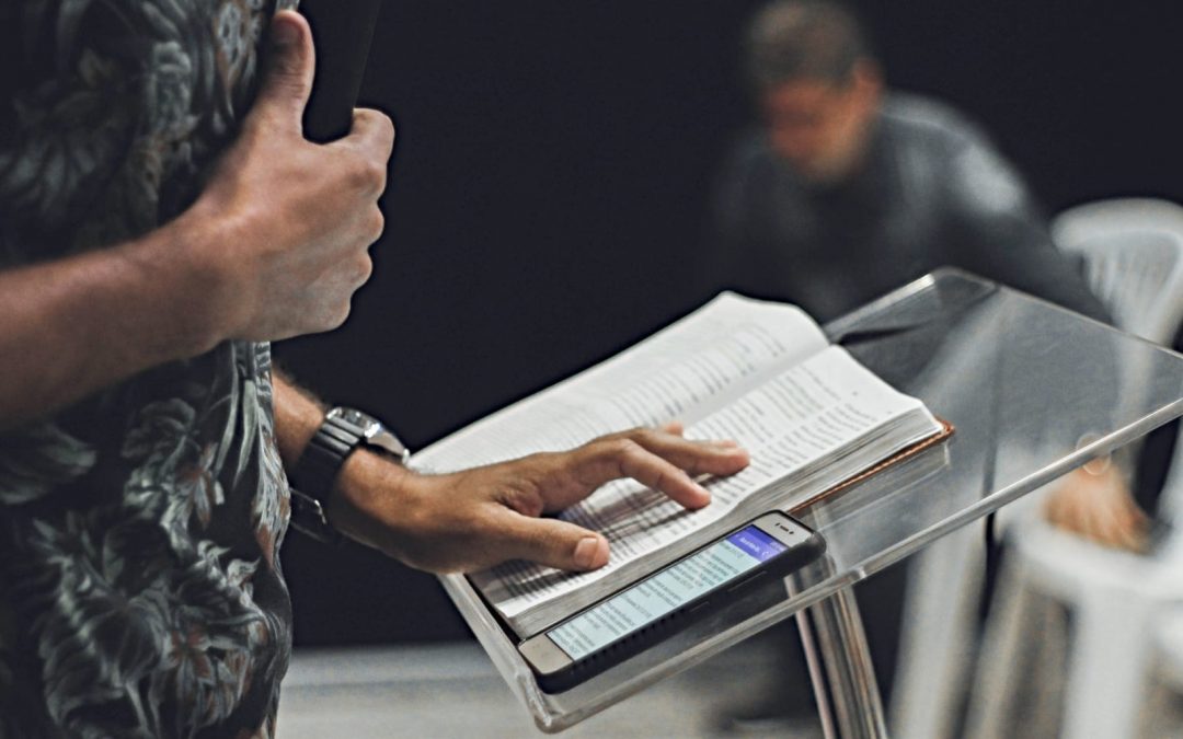 A man preaching with a Bible and iPhone