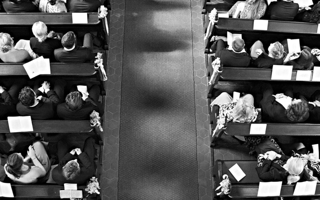 A church congregation sitting in pews seen from above