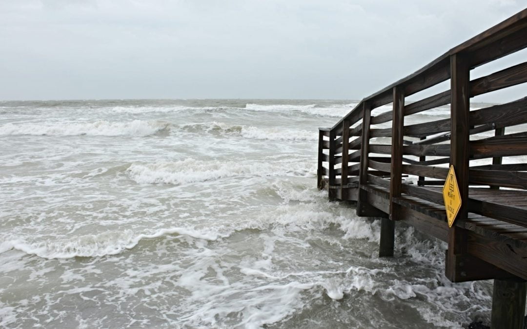 A board walk along the beach surrounded by waves
