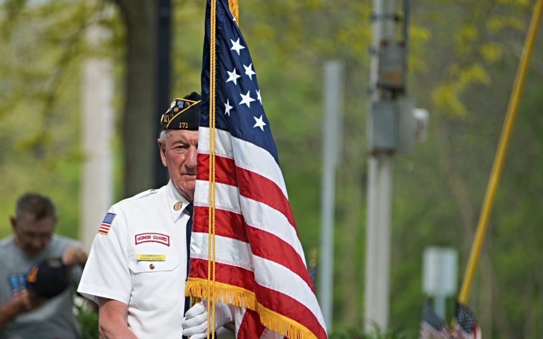 A military veteran carrying a U.S. flag
