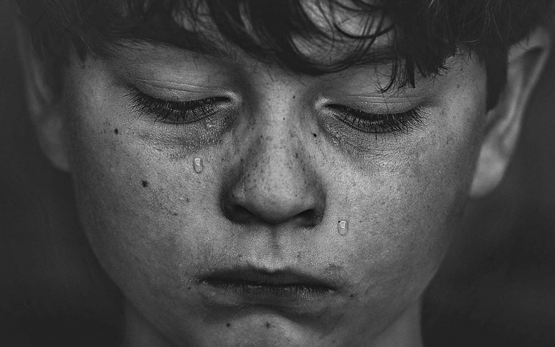 A young boy with tears on his cheeks