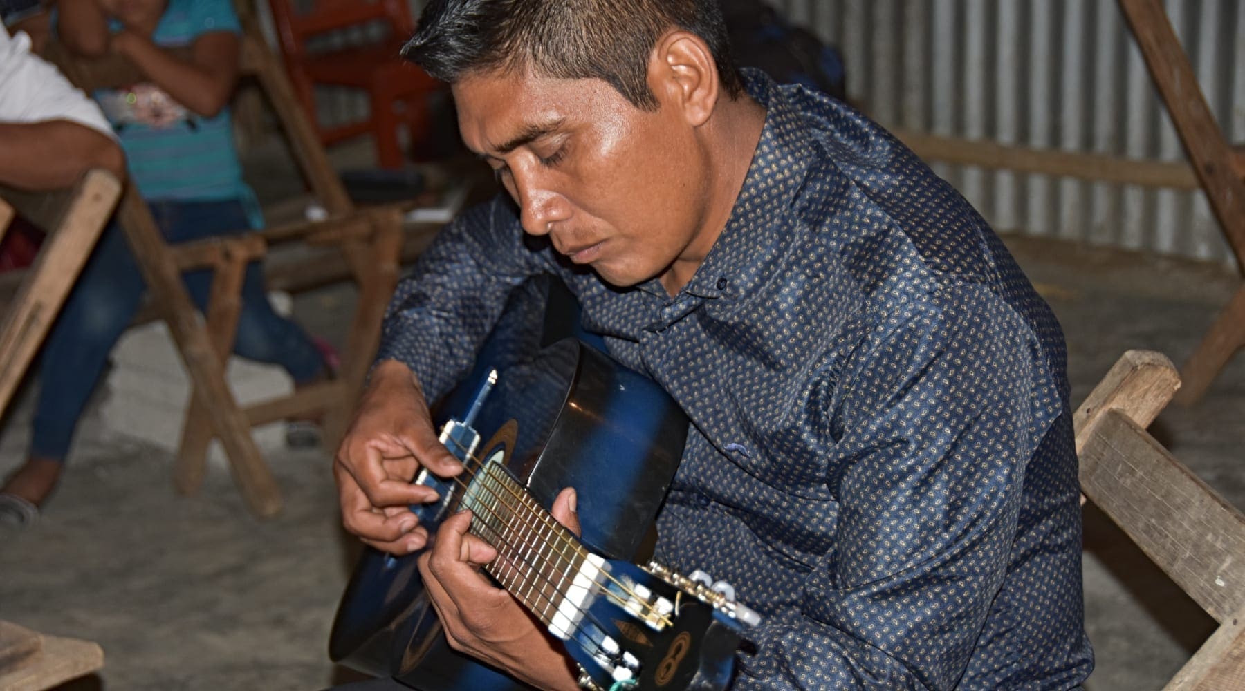 A local pastor in Chiapas playing a blue guitar