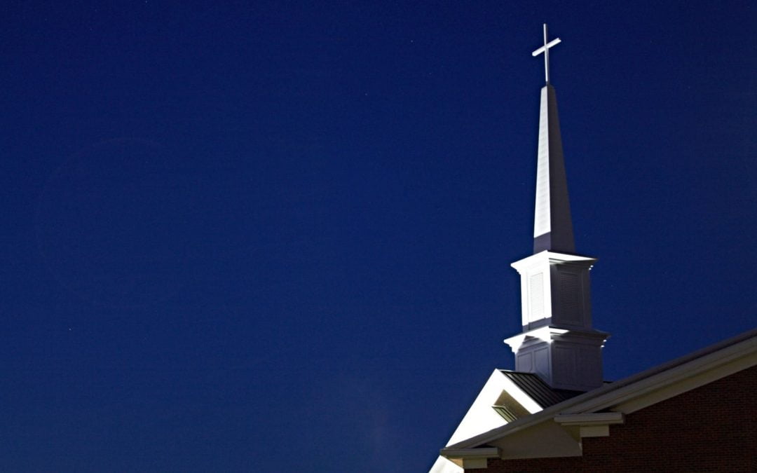 Church steeple with cross and dark blue sky