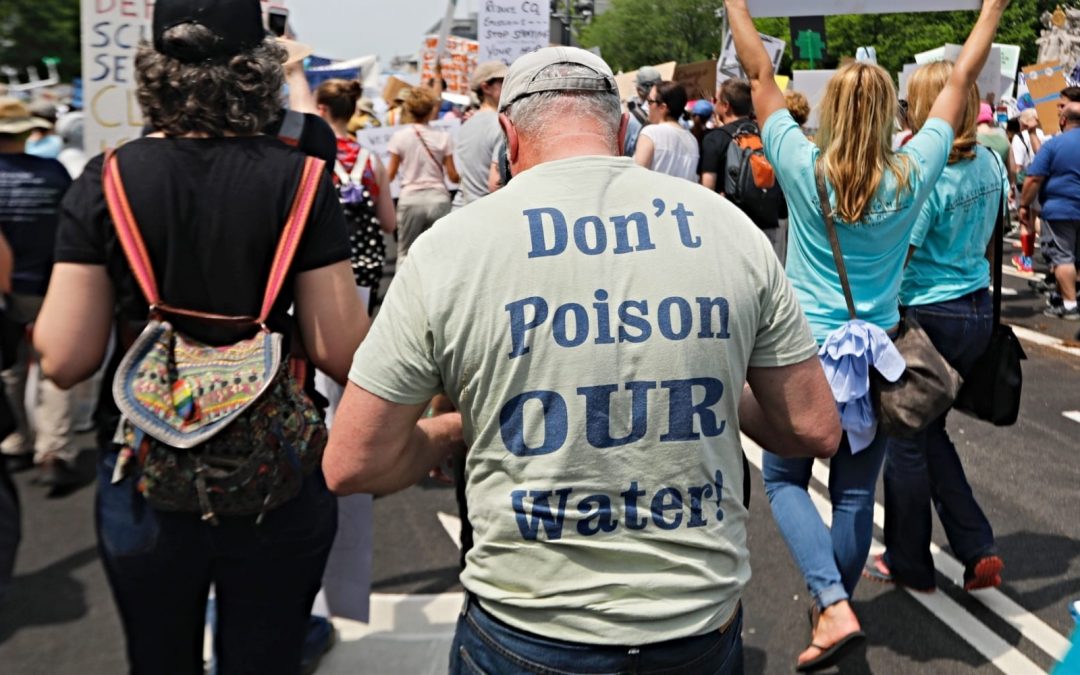 Man marching in crowd protesting water polluting