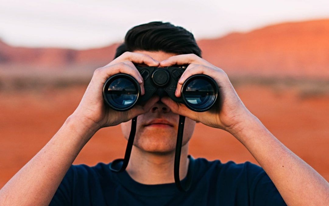 Man using binoculars looking forward