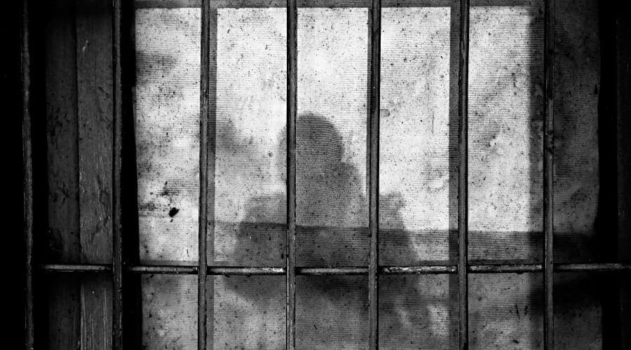 Prison bars with person’s shadow on wall