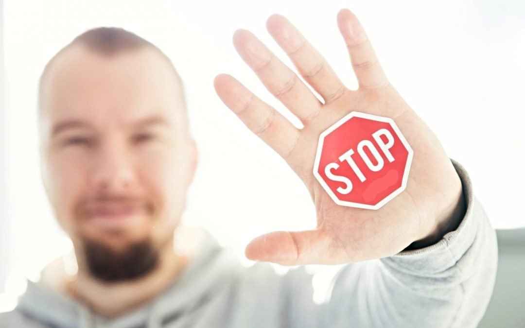 Man holding up hand with stop sign on palm