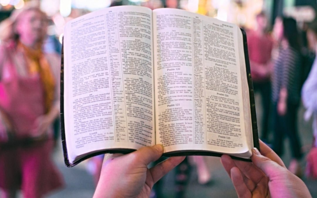 Open Bible with busy street scene in background