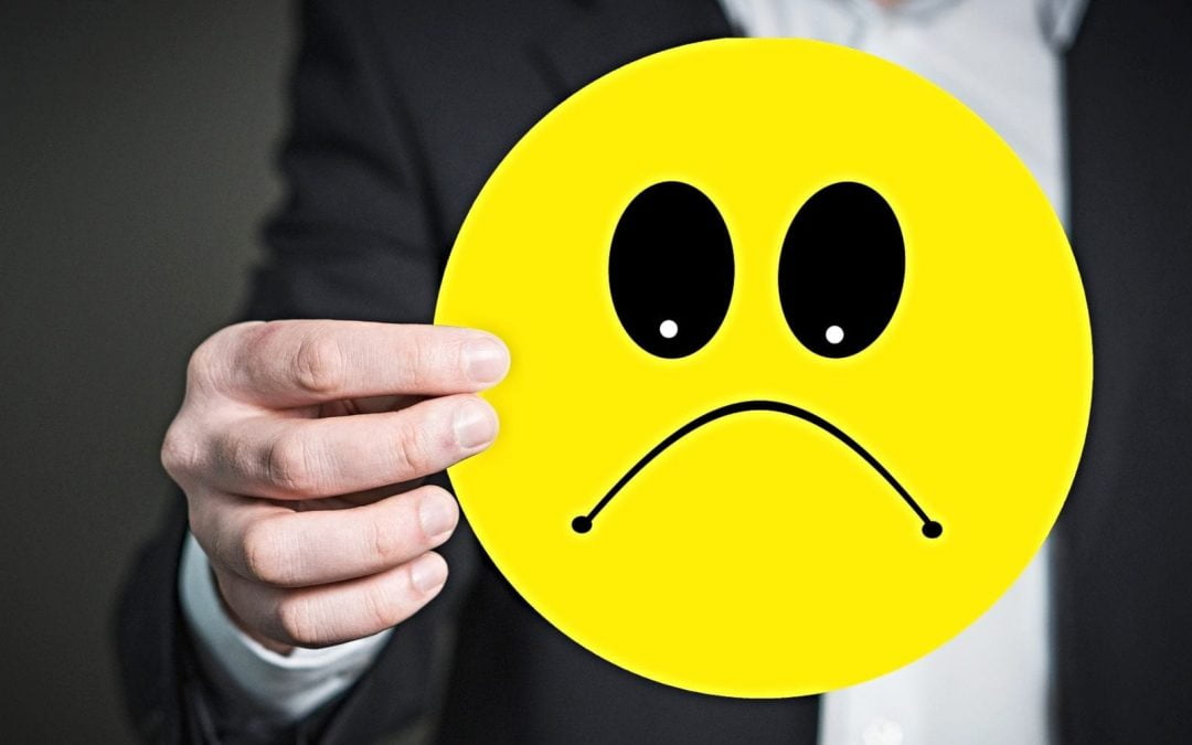 Person holding sad emoji