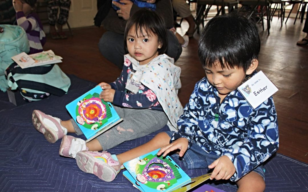 Two seated children reading books