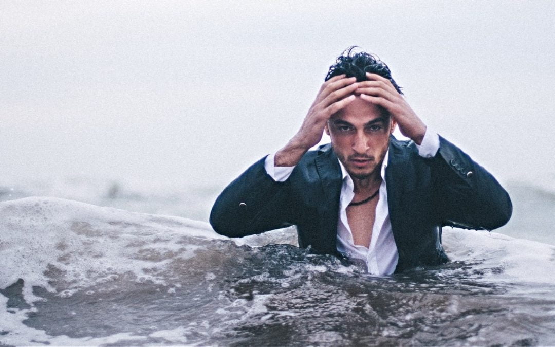 Stressed man standing in ocean