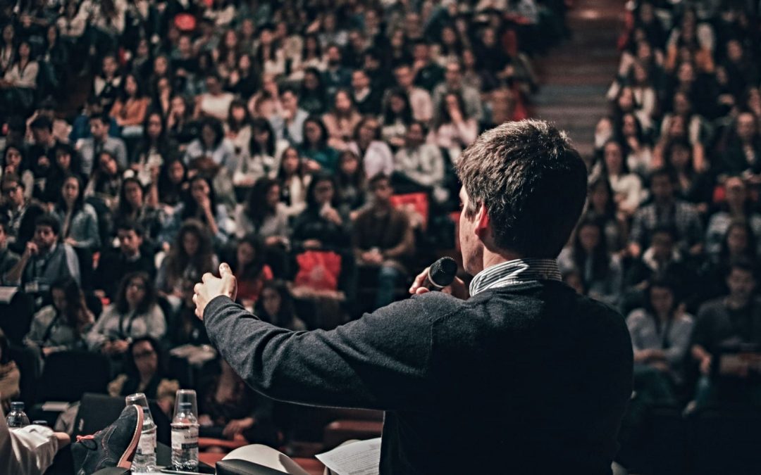 Man speaking to crowd in auditorium