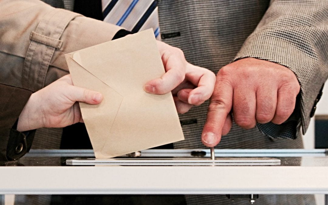 Person casting ballot in box