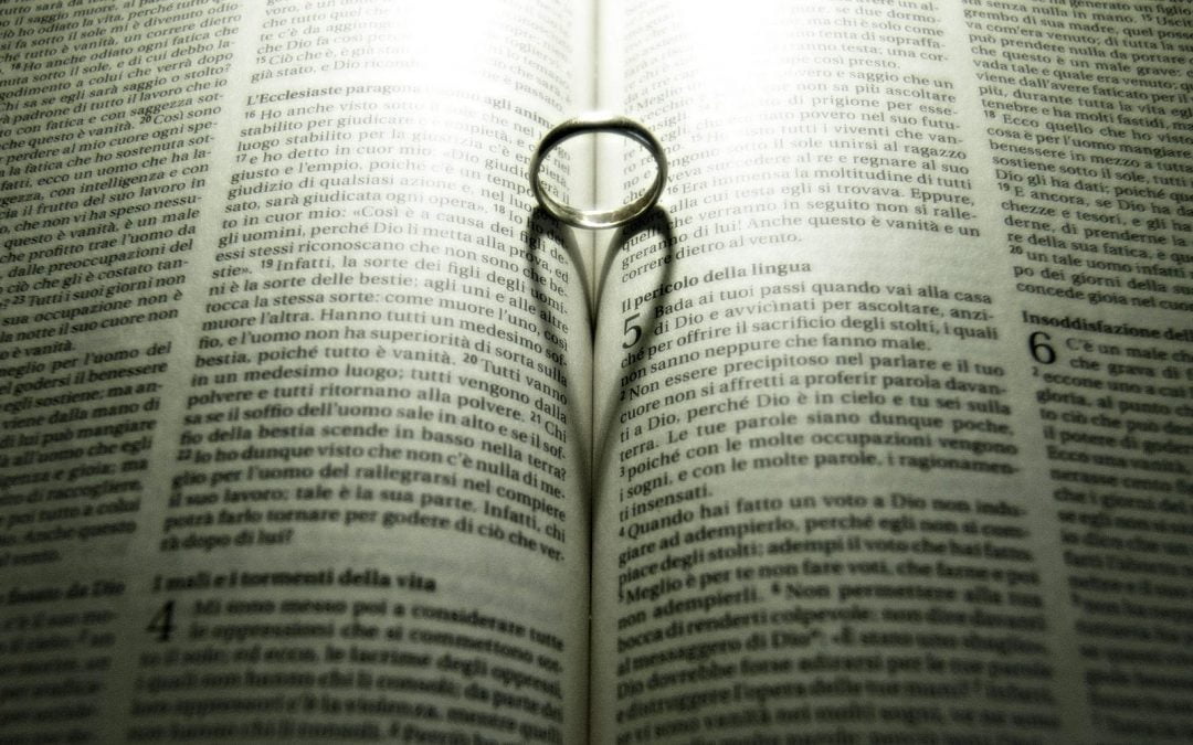 Ring casting heart shadow on pages of Bible