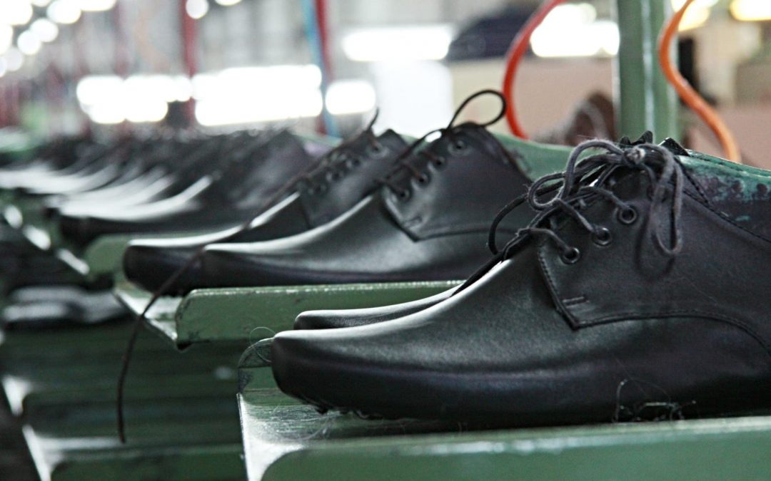Black dress shoes in line at factory