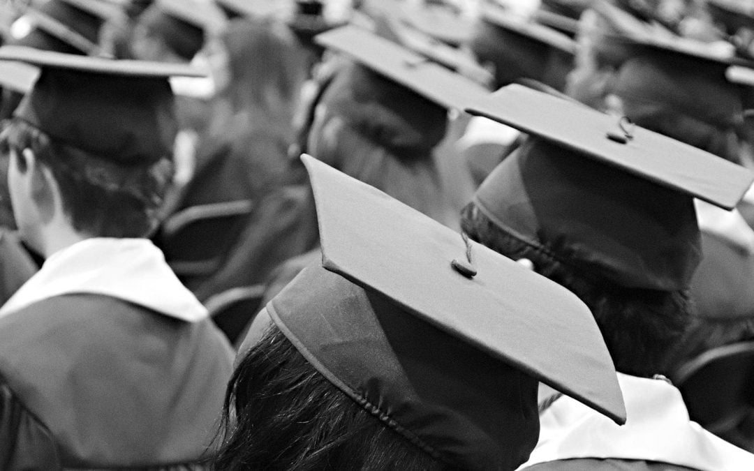 Students wearing caps and gowns at graduation ceremony