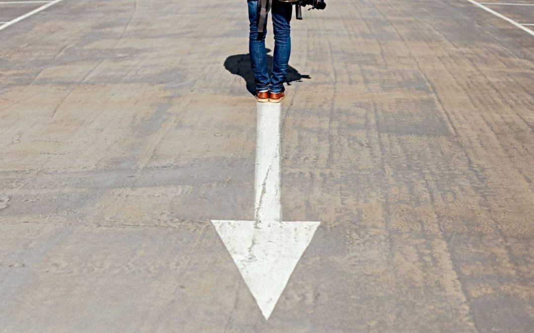 Person standing on downward arrow on street