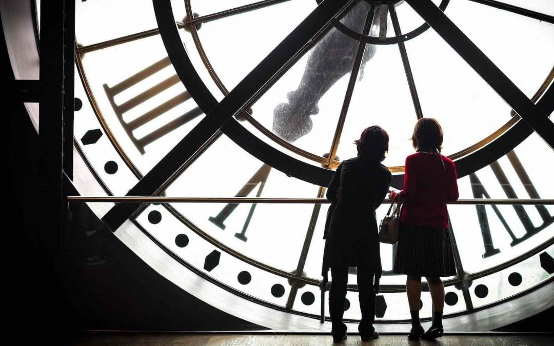 Two people looking at a clock dial from inside.