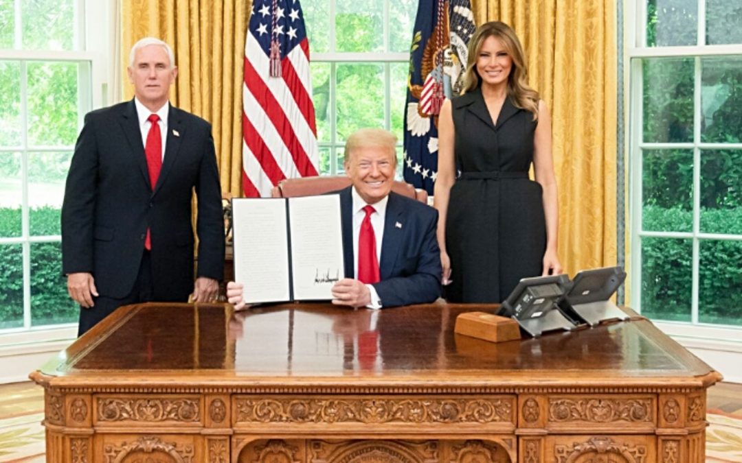 President Trump holding executive order with VP Mike Pence and first lady Melania Trump