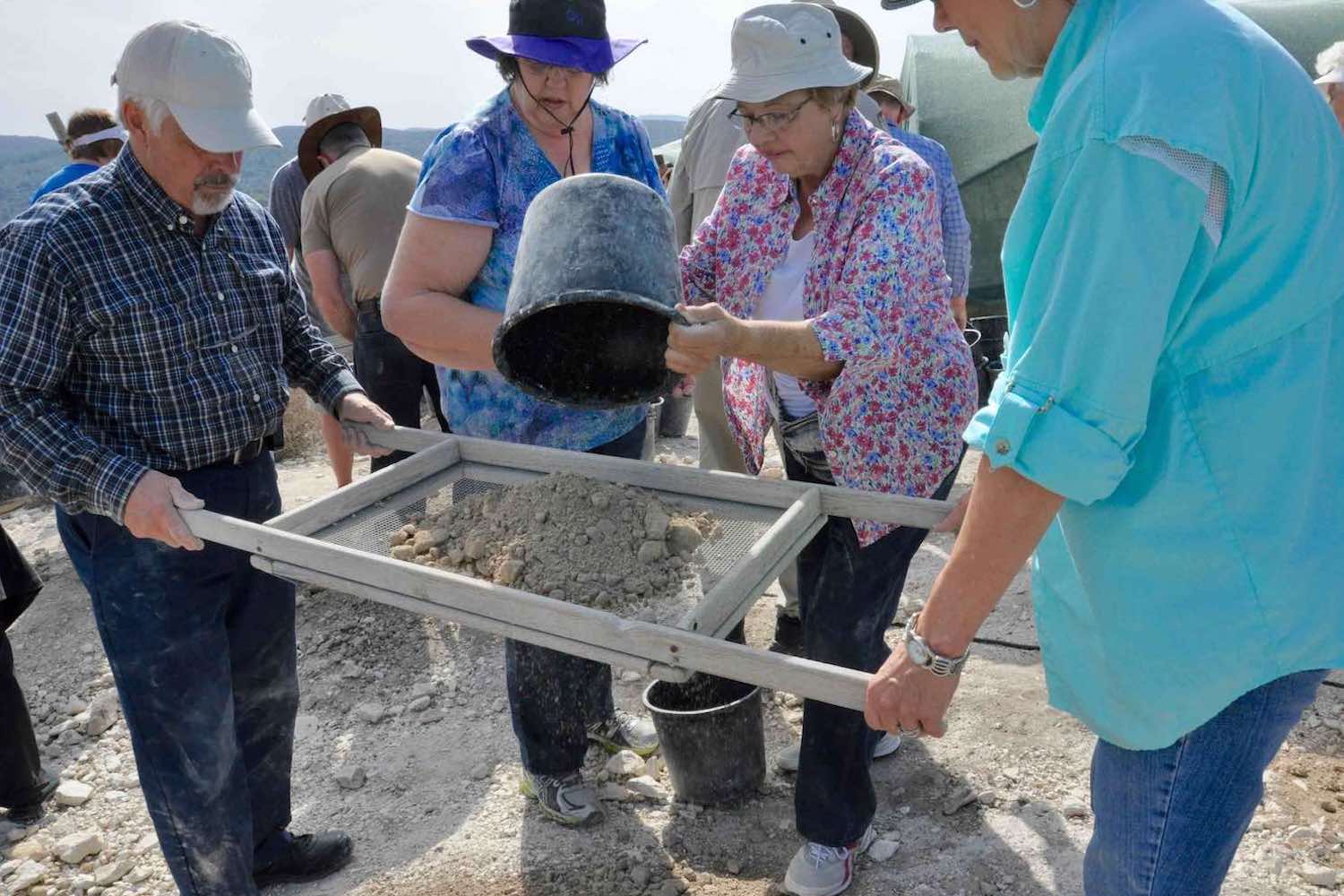 People sifting soil on an archaelogical dig
