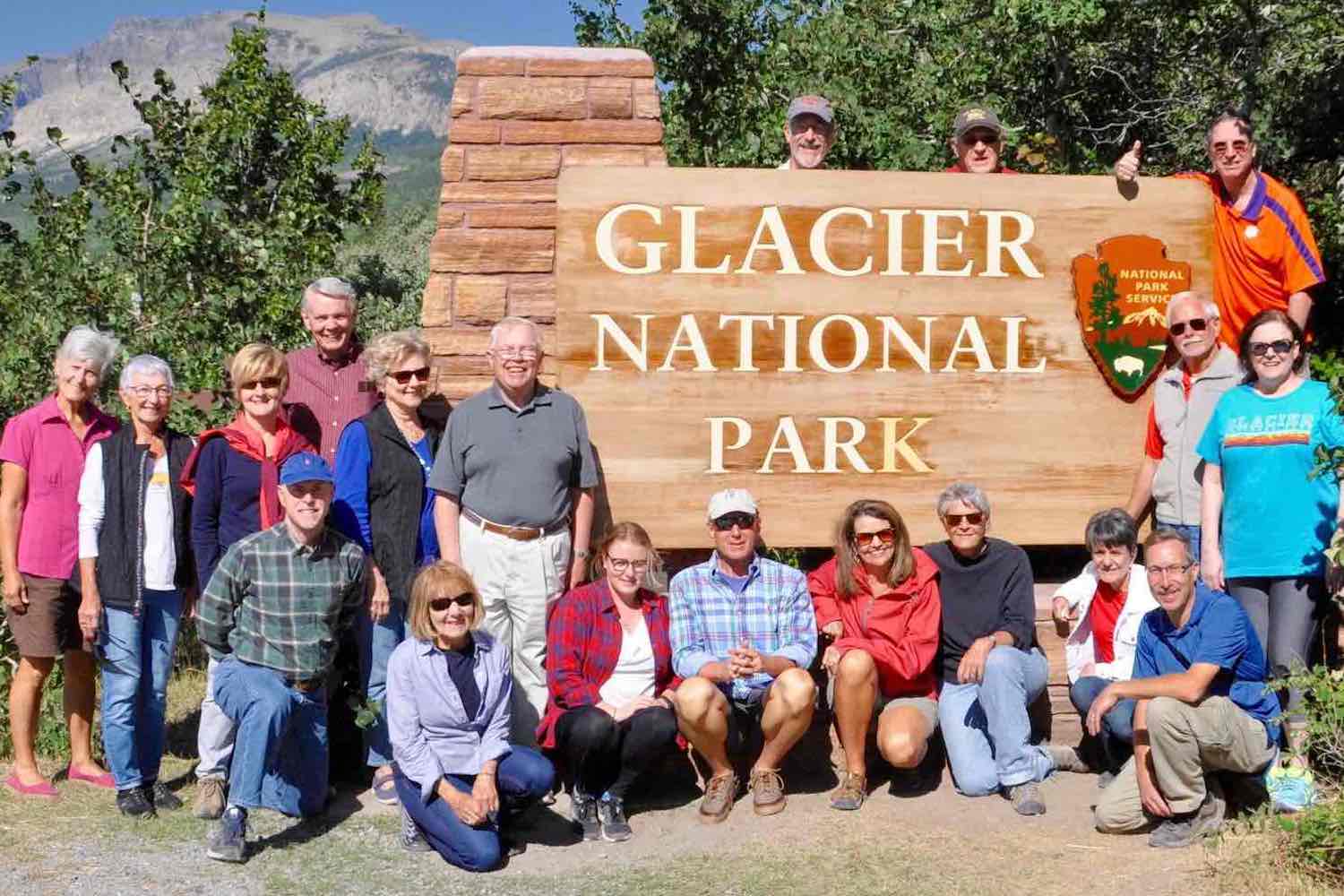 A group in front of a national park sign