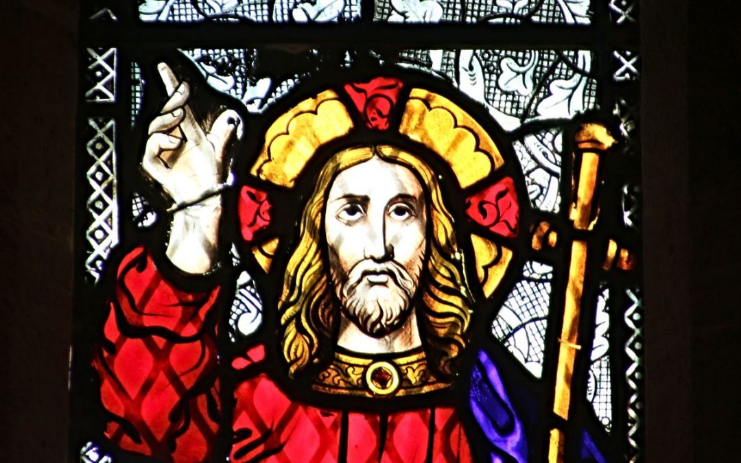 Stained-glass portrait of Jesus pointing upward