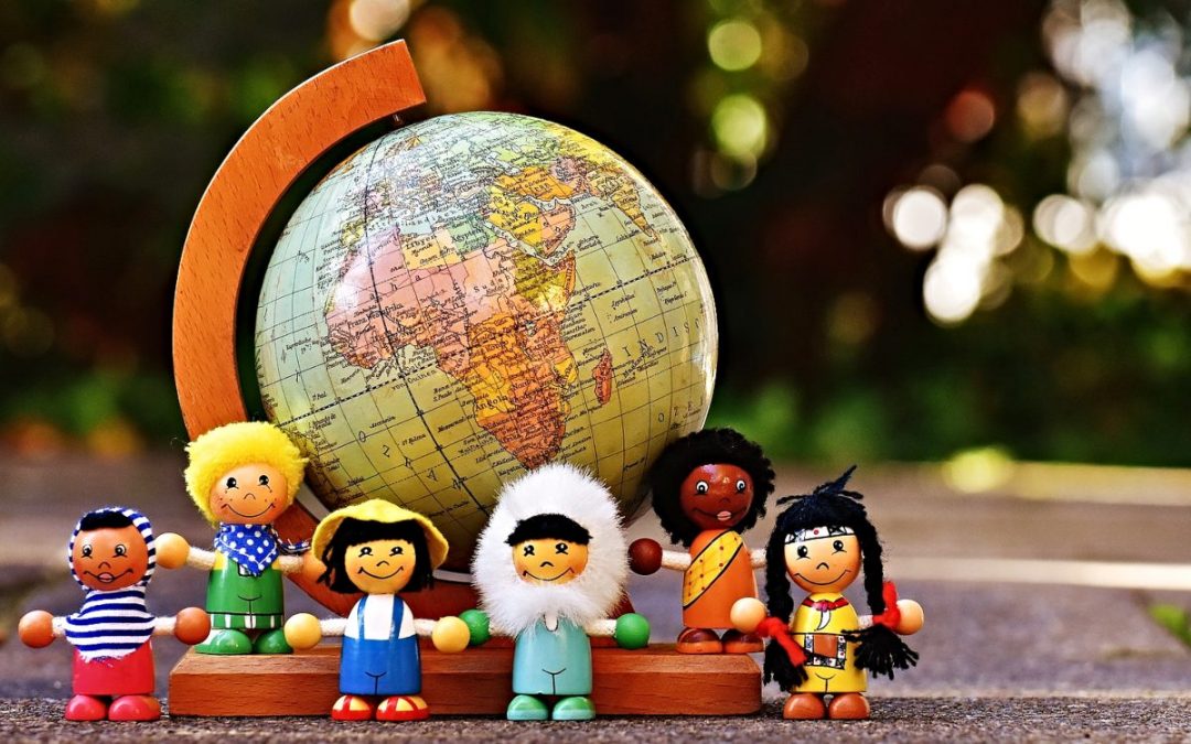 Dolls of different nationalities in front of globe