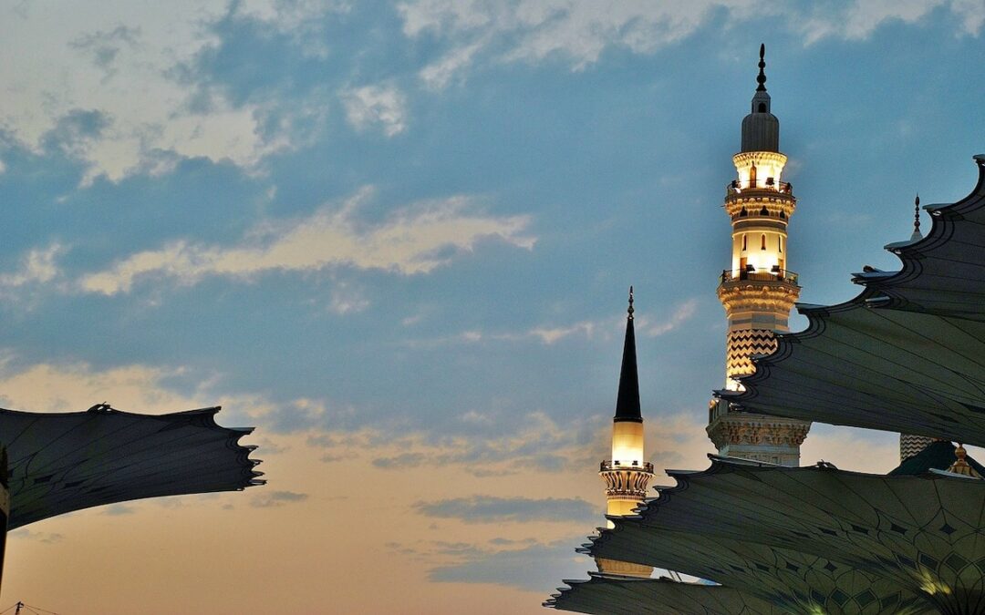 Two lighted towers against a darkening sky in the city of Mecca.