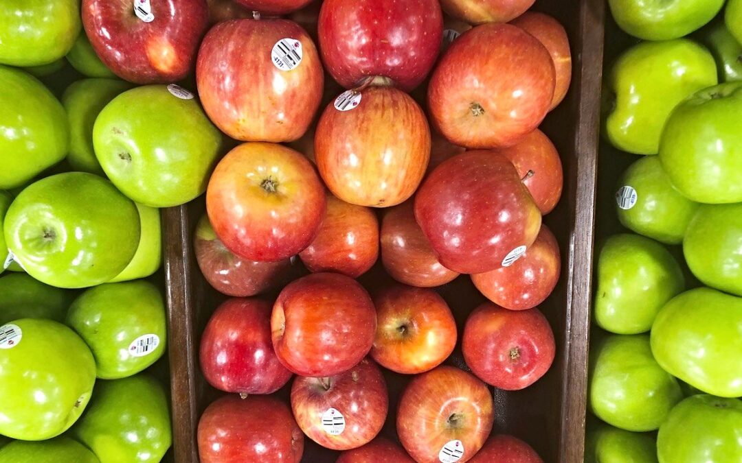 A display of green and red apples in a supermarket.