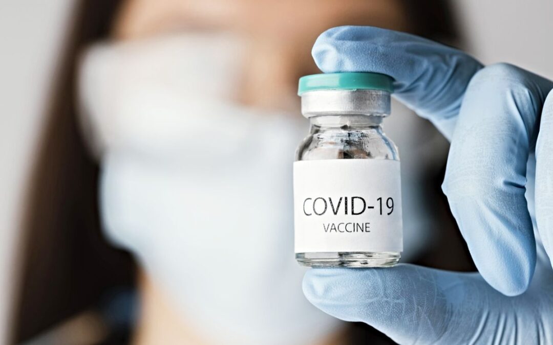 Medical professional holding vial of COVID-19 vaccine