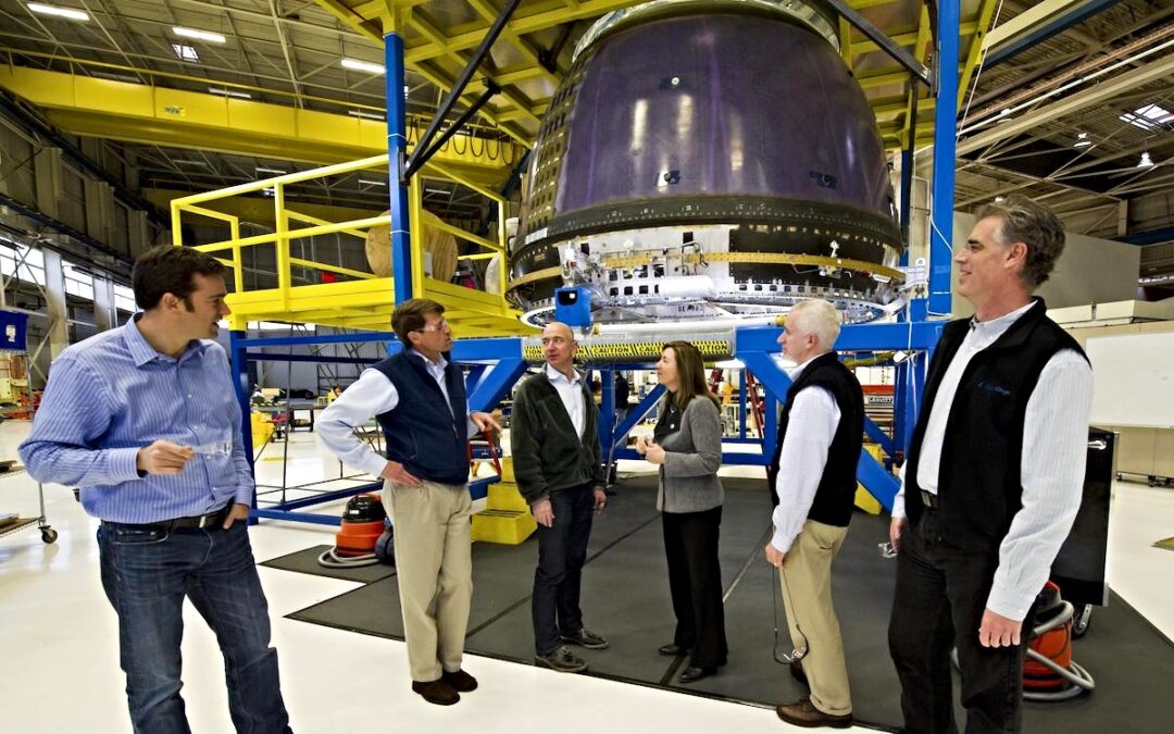 NASA Deputy Administrator Lori Garver, fourth from left, meets Blue Origin Founder Jeff Bezos, third from left, next to Blue Origin's crew capsule along with other Blue Origin team members.