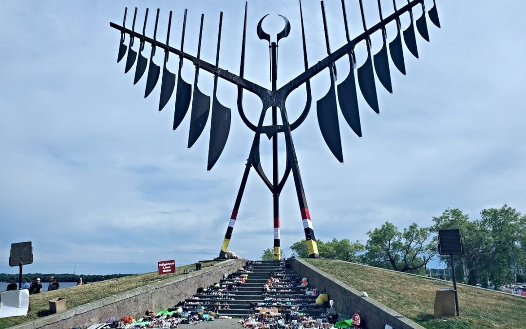 The Spirit Catcher statue in Barrie, Ontario, Canada, is adorned with children's footwear in memory of children recently found in an unmarked grave.
