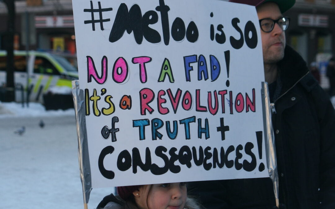 A young girl holding a sign that says, “#MeToo is so not a fad! It’s a revolution of truth and consequences.”