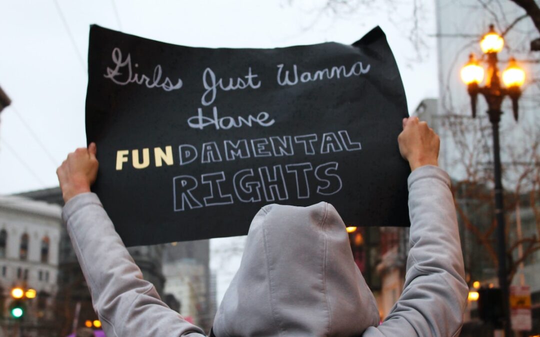 A woman holding a sign that says, “Girls just wanna’ have fundamental rights.”