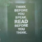 A green book cart with “Think Before You Speak. Read Before You Think” written on the side.