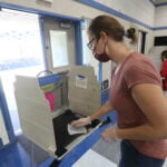 A California poll worker sanitizes a voting booth following its use at a Voter Assistance Center during the 2020 General Election.