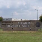 A red brick sign for the Alan B. Polunsky Unit in East Texas.