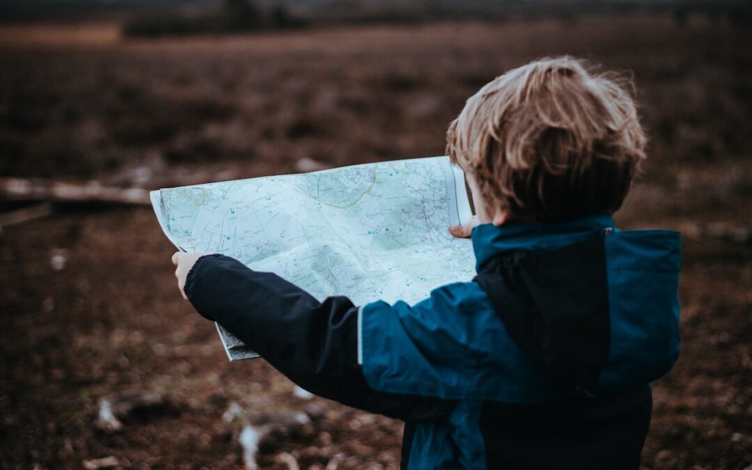 A young boy holding a map.