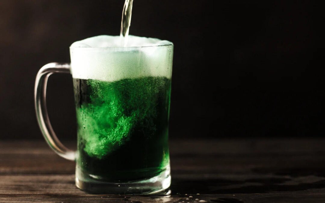 A green colored beverage being poured.