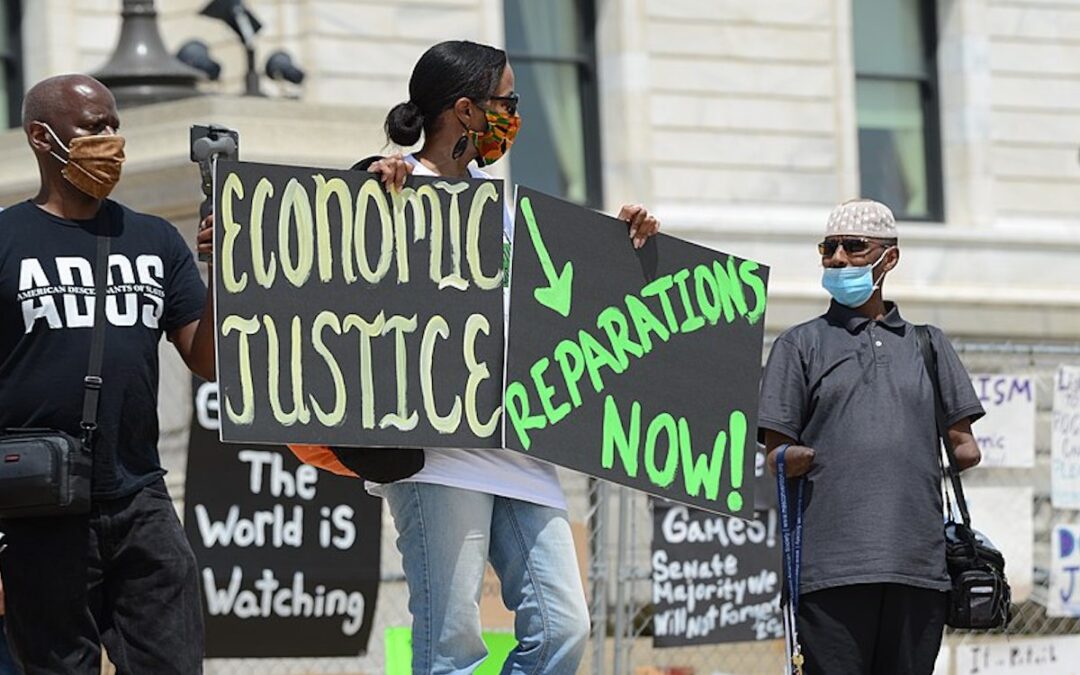 People holding signs calling for economic and racial justice.