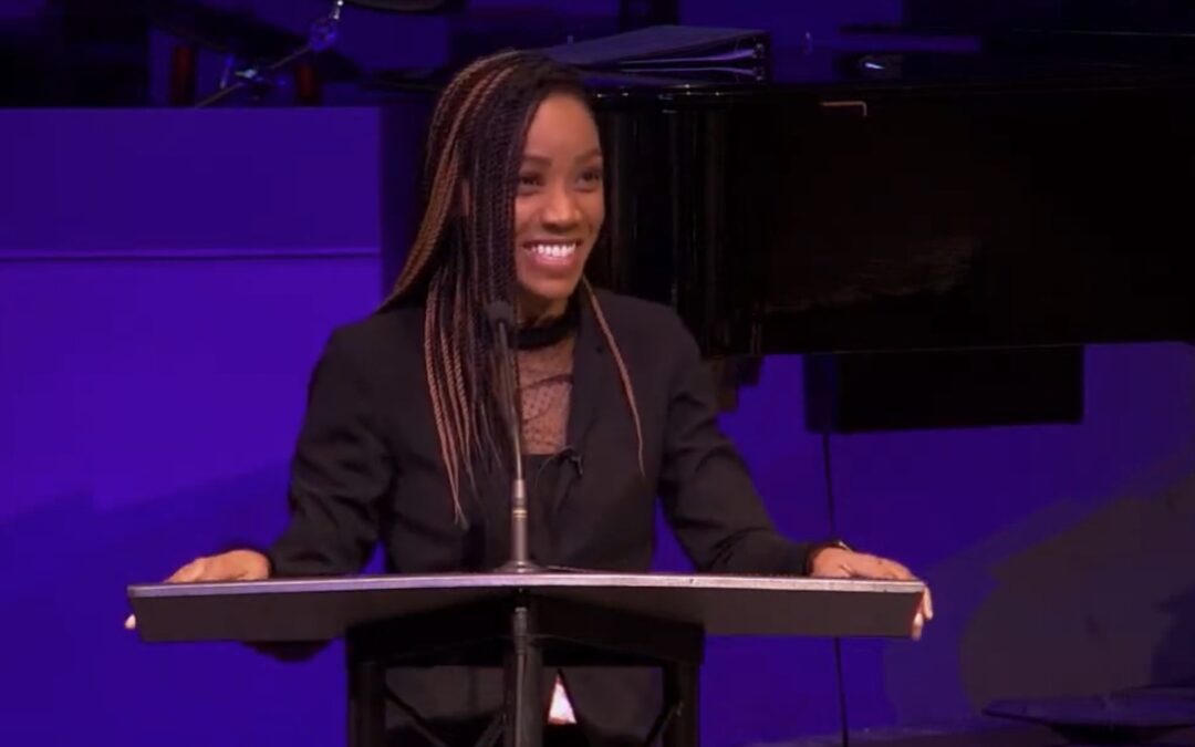 A woman standing behind a pulpit while preaching.