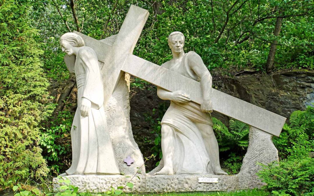 A sculpture depicting Simon of Cyrene helping Jesus carry the cross.