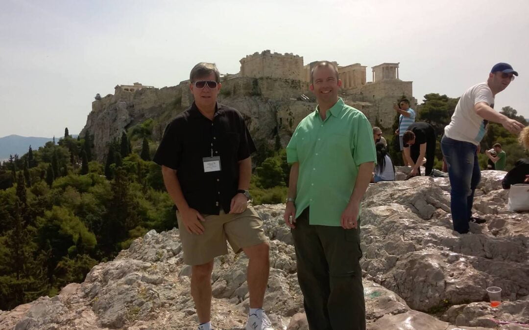 Two men standing on a hillside in Greece.