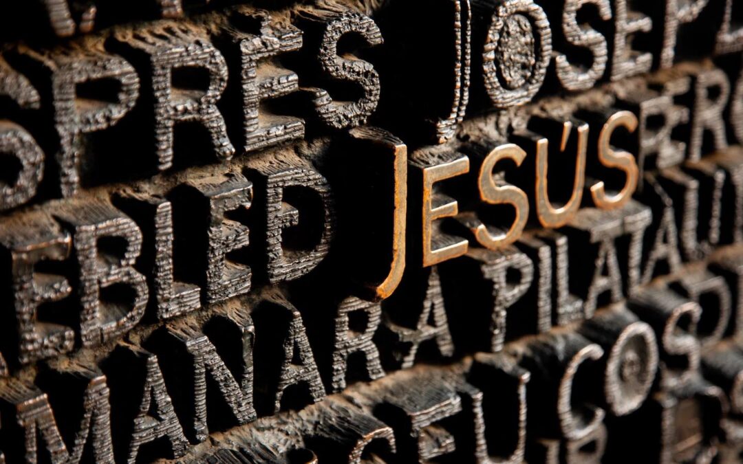 The name “Jesus” in gold lettering on a wall surrounding by other names.
