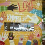 A small mural of hands with hearts on them, with words of admonition to be kind, show love and so forth.