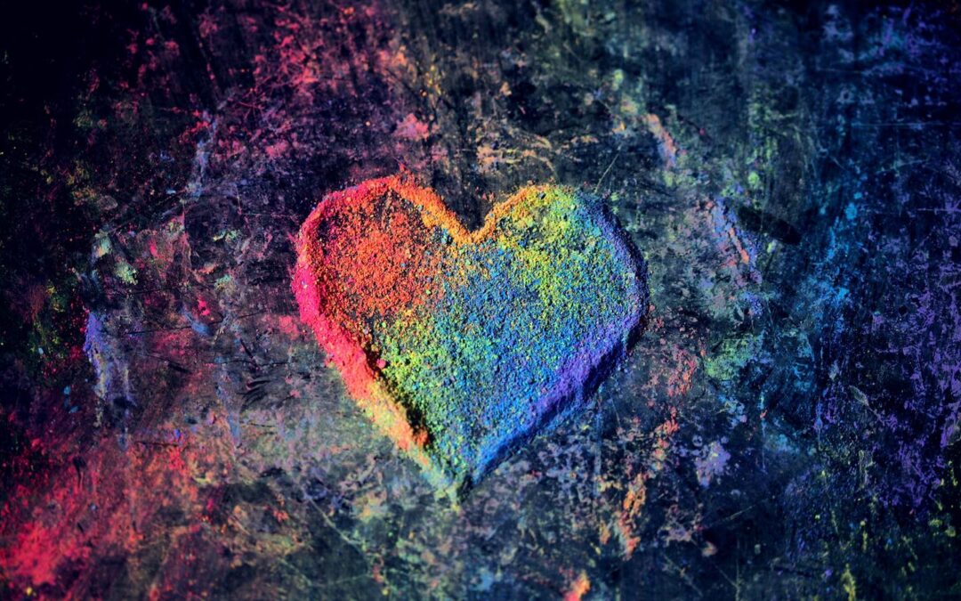 A rainbow-colored heart formed by colorful chalk.