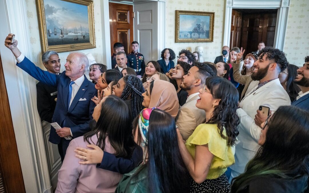 President Biden taking a selfie with a group of younger adults.