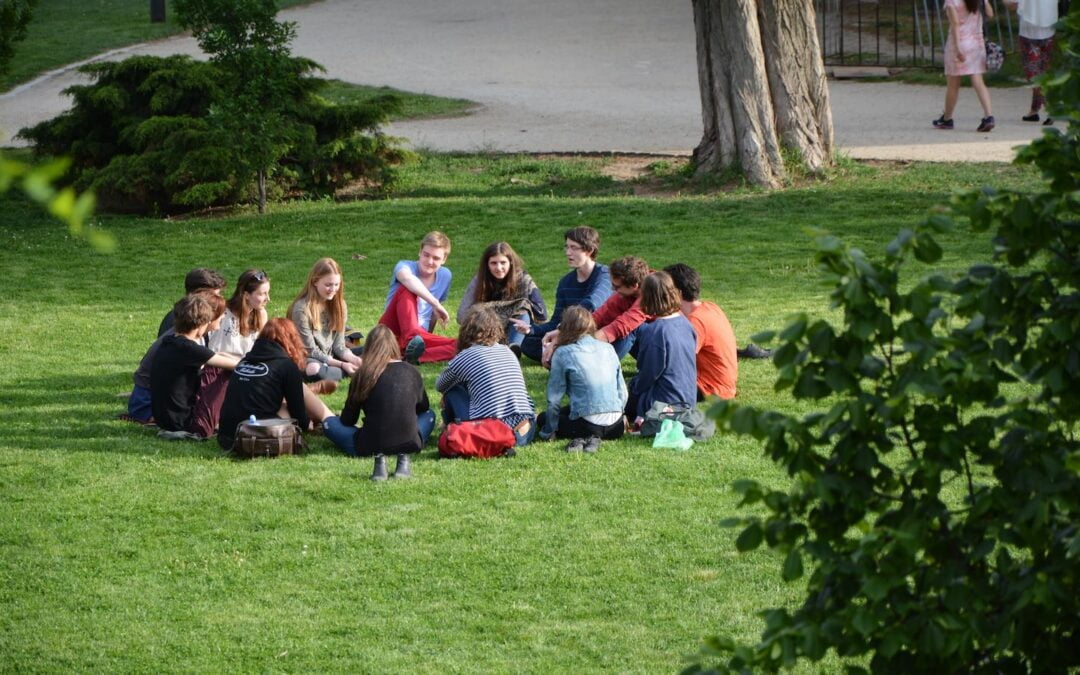 A group of college students sitting outside in a circle.